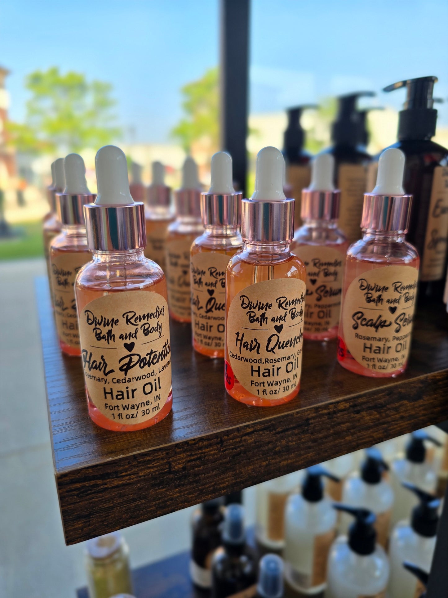 Row of small bottles with droppers on a wooden surface, blurred outdoor background