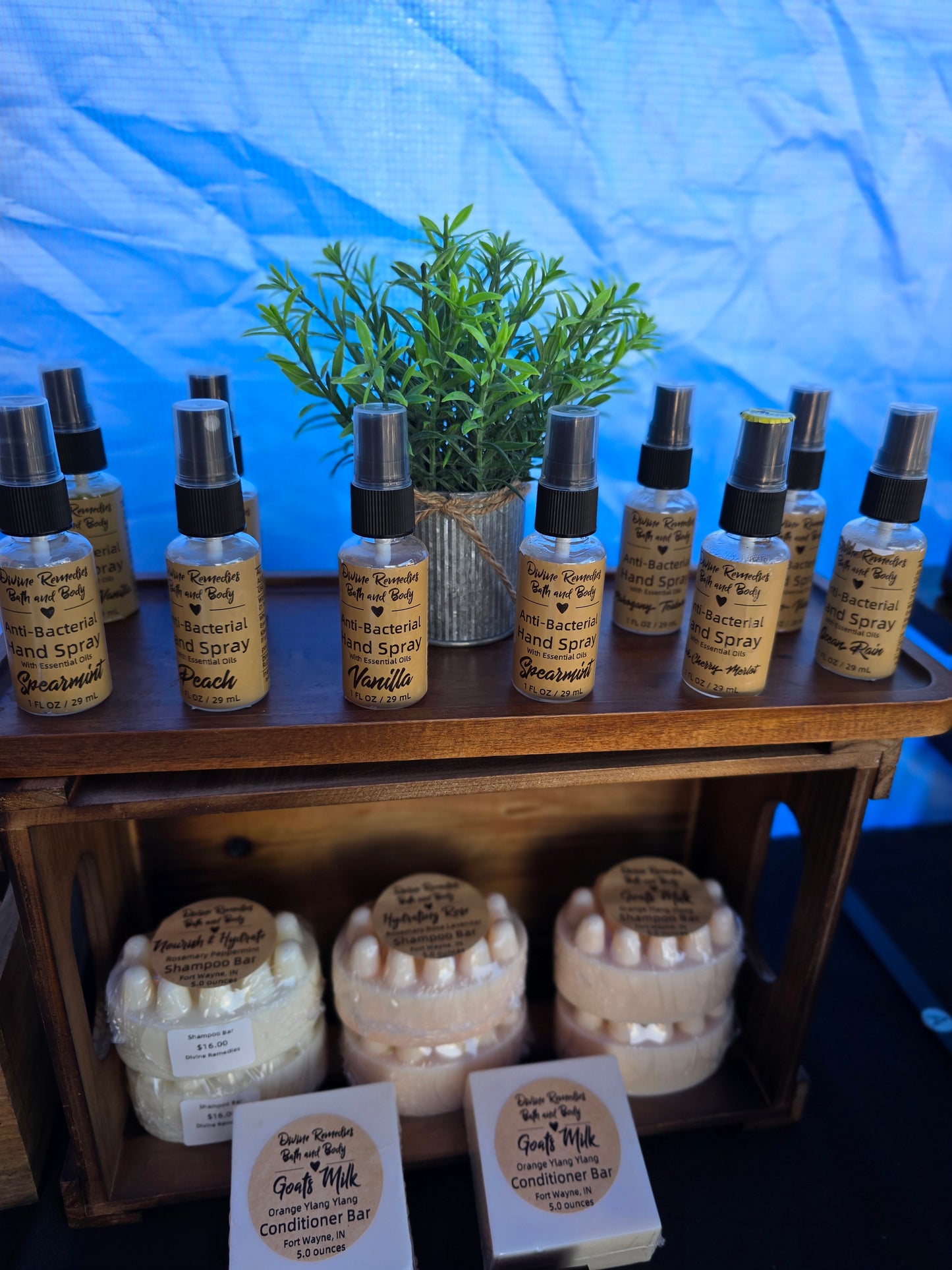 Collection of small bottles and containers on a wooden shelf with a blue background