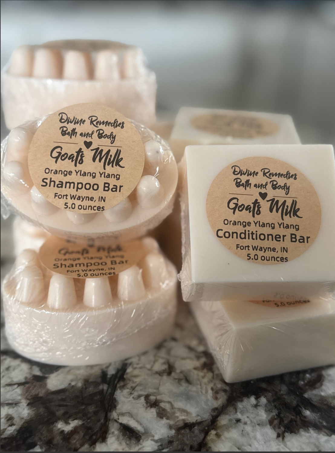 Goat's Milk shampoo and conditioner bars on a marble surface