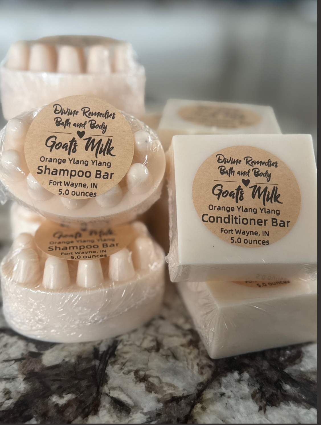 Goat's Milk shampoo and conditioner bars on a marble surface