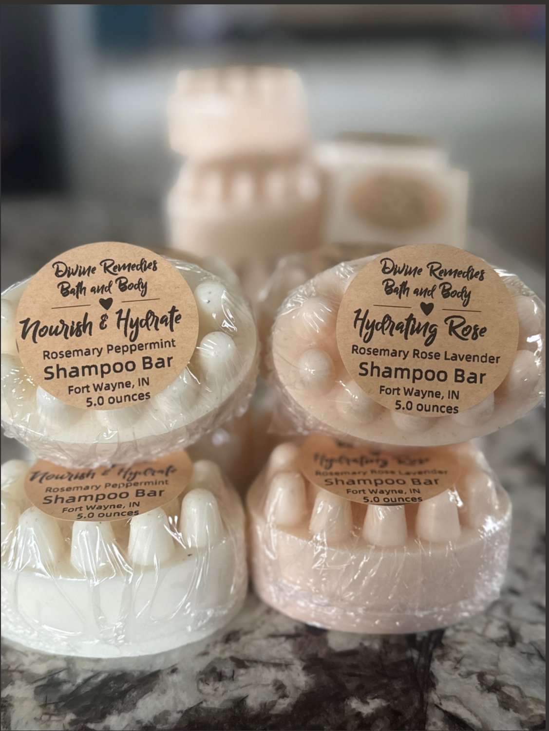 Three soap bars with labels on a marble surface