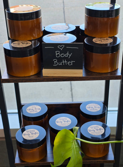 Collection of body butters in a decorative stand with a plant in the background.