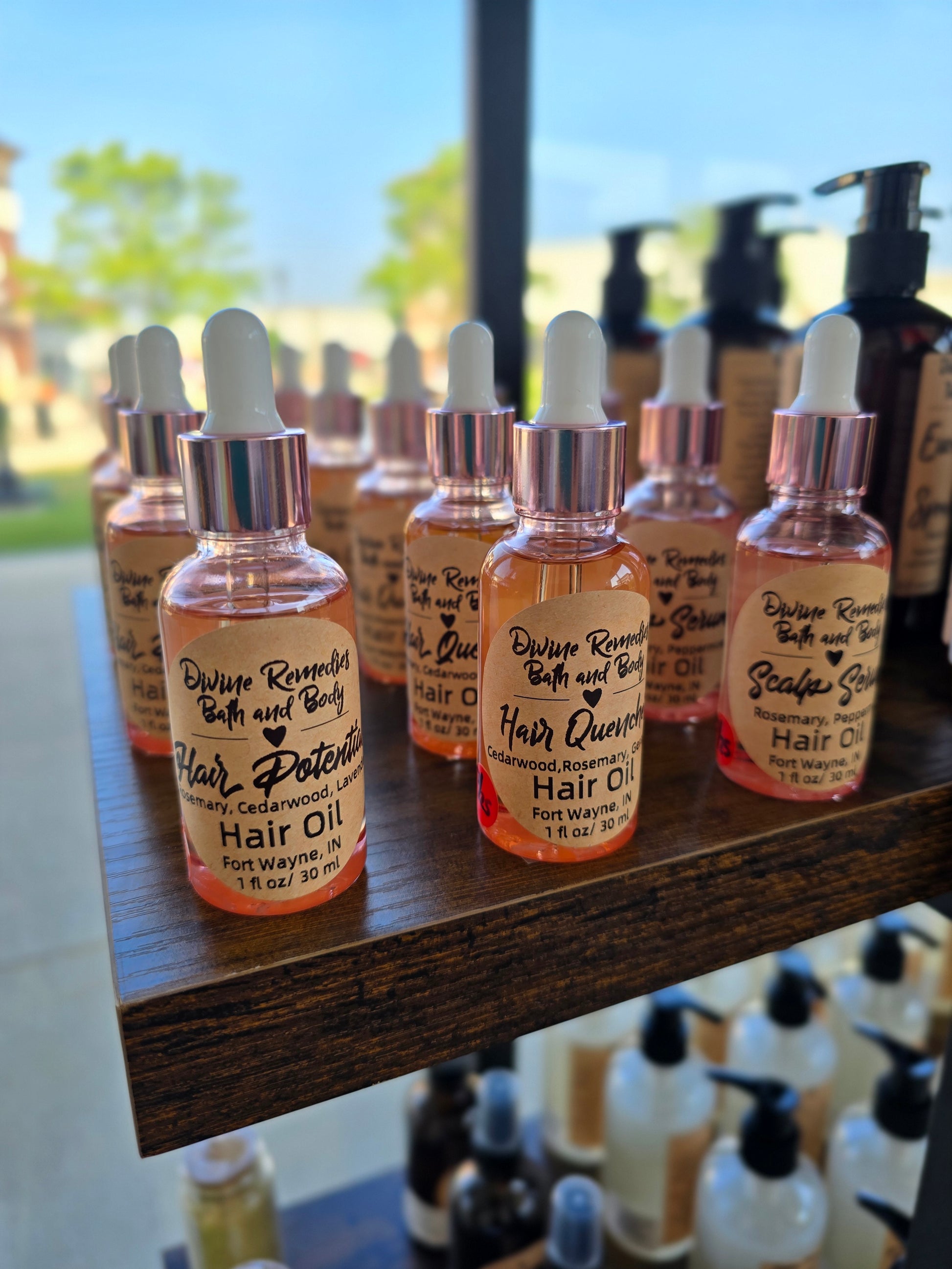 Row of small bottles with droppers on a wooden surface, blurred outdoor background