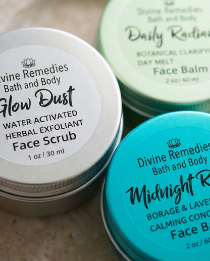 Close-up of Glow Dust, Midnight Rescue, and Daily Radiance skincare tins by Divine Remedies.